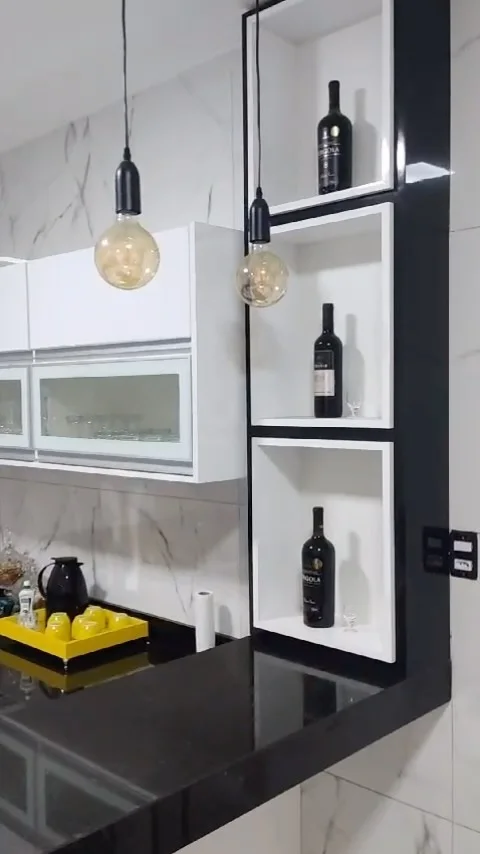 Nichos brancos com contorno preto e garrafas, ao lado da bancada preta